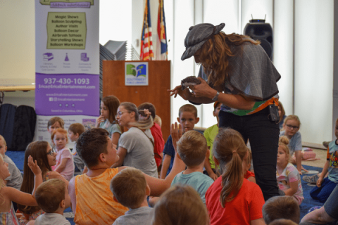 Children's entertainer Erica Carlson presenting a magic show featuring a live hedgehog to a group of children