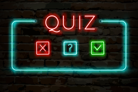 the word "Quiz" in neon lights along with "X" "?" and check mark icons in neon lights