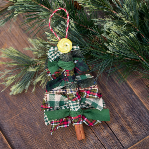 Decorative holiday tree ornament made from scraps of festive fabric tied around a cinnamon stick