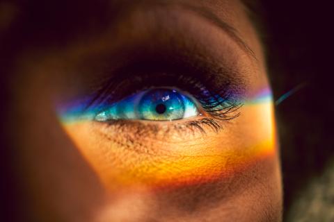 photo of rainbow spectrum of light shining across someone's eye