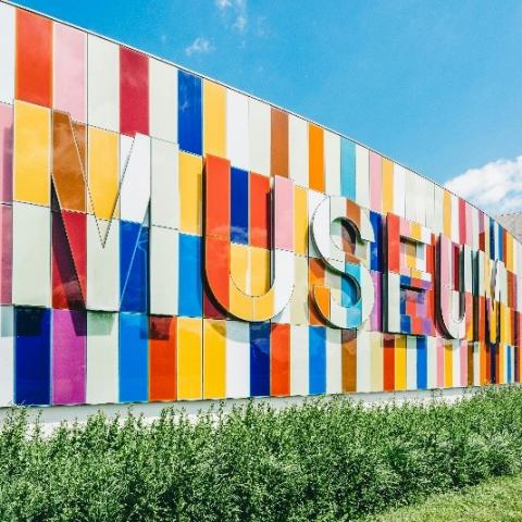 Multi-colored wall with the word Museum on it.