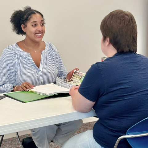 Woman helping another woman find resources