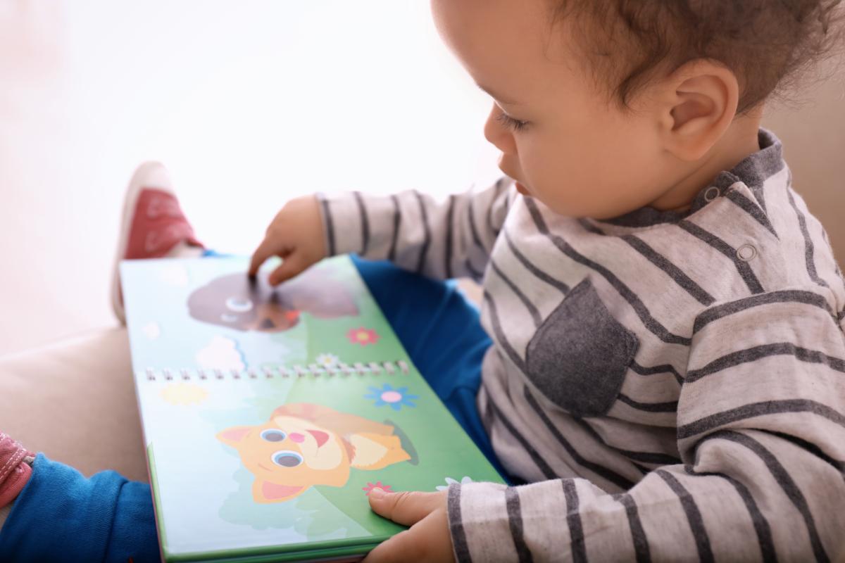 Photo of baby reading board book