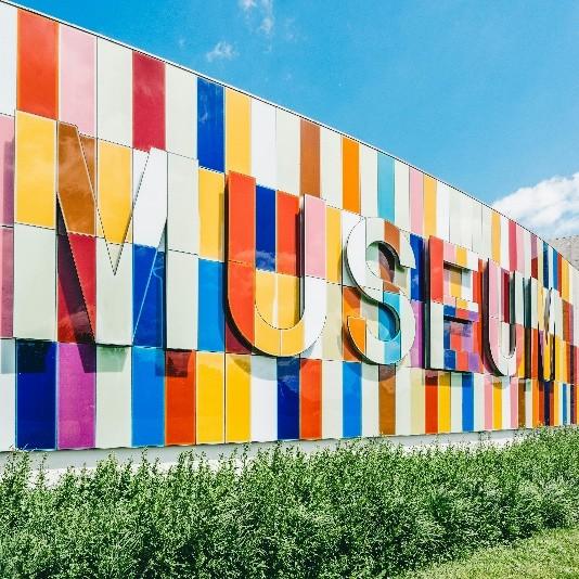 Multi-colored wall with the word Museum on it.