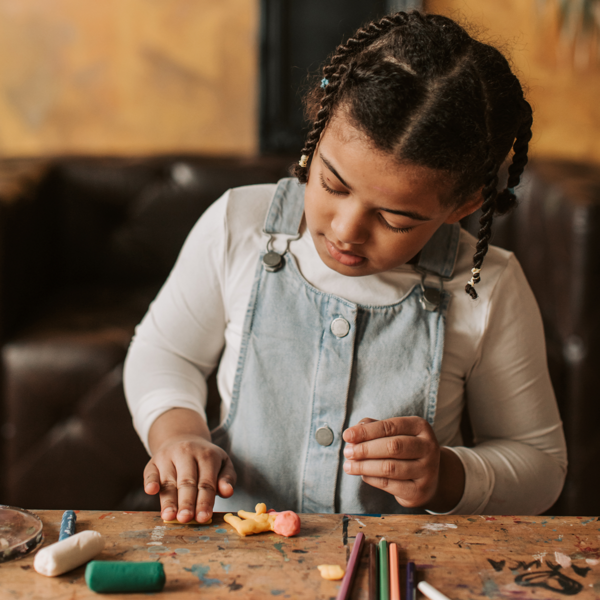 Kid crafting with clay and colored pencils